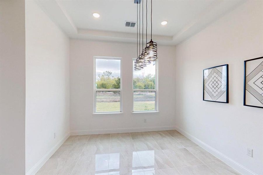 Unfurnished dining area with a raised ceiling