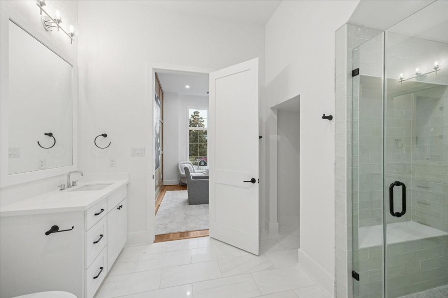 Designed to support flexible living, the first floor bath includes a walk in shower and generous vanity, making the adjacent study function easily as a private guest suite. Clean finishes and direct access enhance everyday convenience while maintaining separation from main living spaces. Designed to support flexible living, the first floor bath includes a walk in shower and generous vanity, making the adjacent study function easily as a private guest suite. Clean finishes and direct access enhance everyday convenience while maintaining separation from main living spaces.