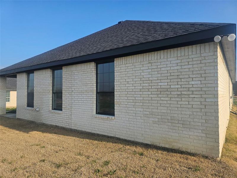 View of side of property featuring a lawn