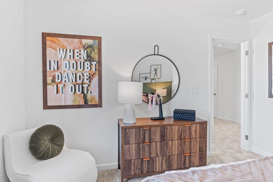 A room with a mirror and a dresser.