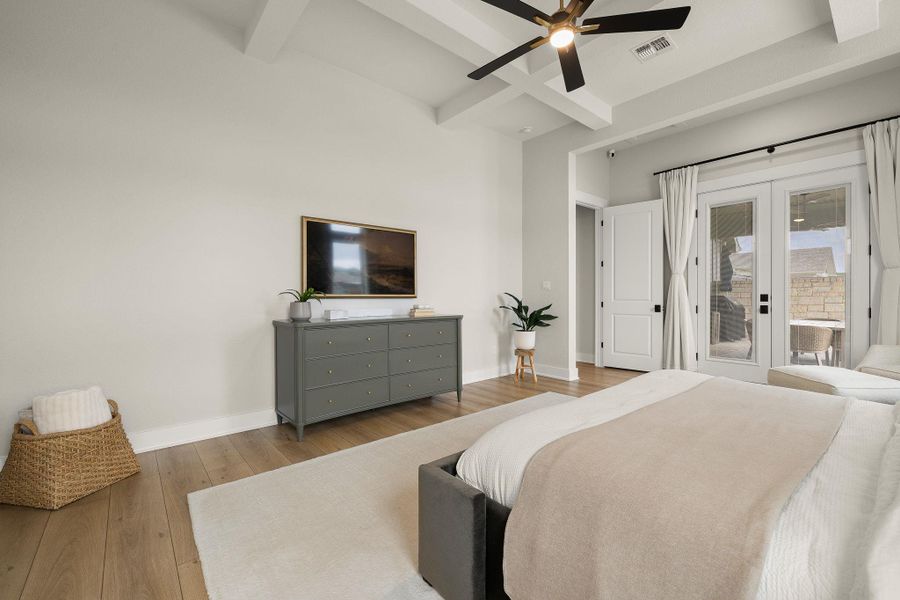 Spacious primary retreat with tray ceiling and serene backyard views.