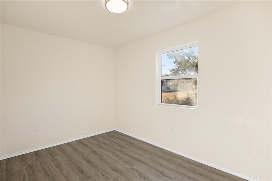 Unfurnished room with dark wood-type flooring