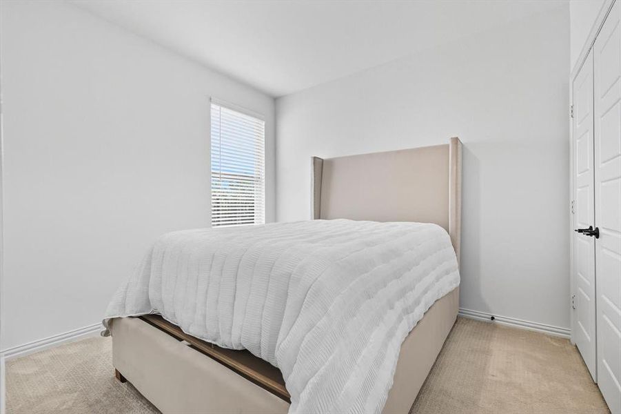 Bedroom featuring light carpet and a closet