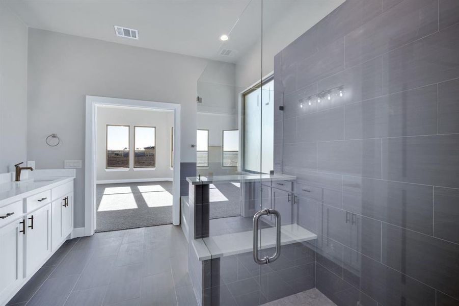 Bathroom featuring tile patterned flooring, vanity, and an enclosed shower