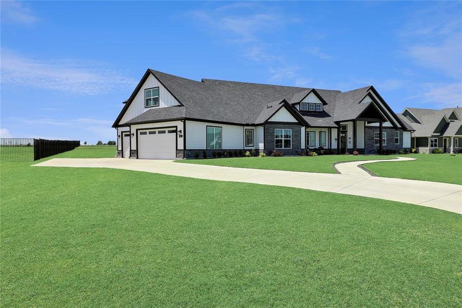 Modern farmhouse style home with stone siding, concrete driveway, and roof with shingles Modern farmhouse style home with stone siding, concrete driveway, and roof with shingles