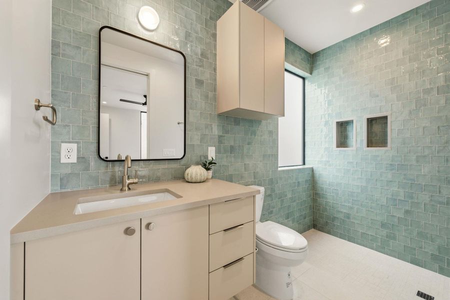 Refined bathroom with a sleek vanity and vibrant tile work creates a tranquil atmosphere. Refined bathroom with a sleek vanity and vibrant tile work creates a tranquil atmosphere.