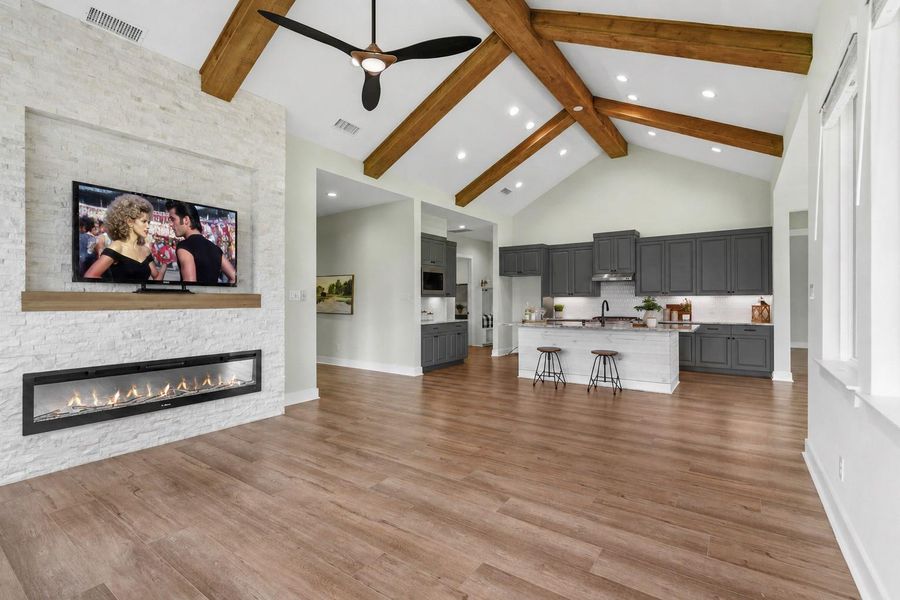 The Family Room flows effortlessly into the Kitchen, creating a seamless and inviting open-concept living space. Unifying the two rooms is a breathtaking, sky-high cathedral ceiling, beautifully accentuated by dramatic wood beams that add warmth, character, and architectural distinction.
