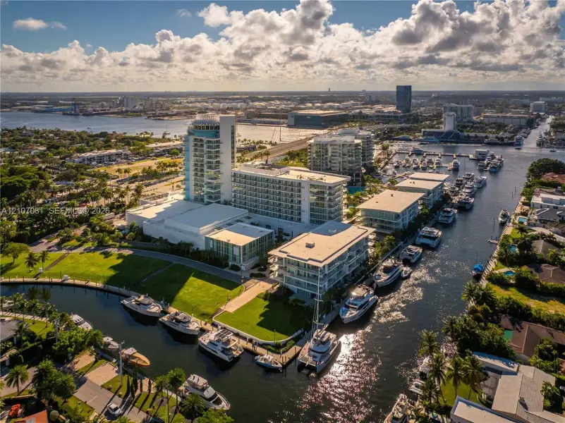 Aerial perspective of a multi-structure complex featuring deep-water canal access, private boat slips, extensive manicured lawn areas, and proximity to coastal waterways Aerial perspective of a multi-structure complex featuring deep-water canal access, private boat slips, extensive manicured lawn areas, and proximity to coastal waterways