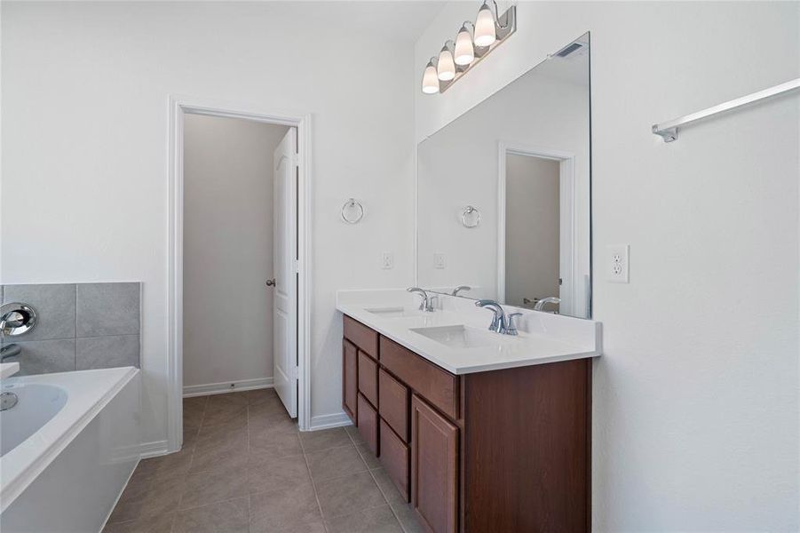 This large primary bath is spacious enough to share! With separate vanities, plentiful cabinet and counter space, you are sure to have private area while sharing this bathroom!