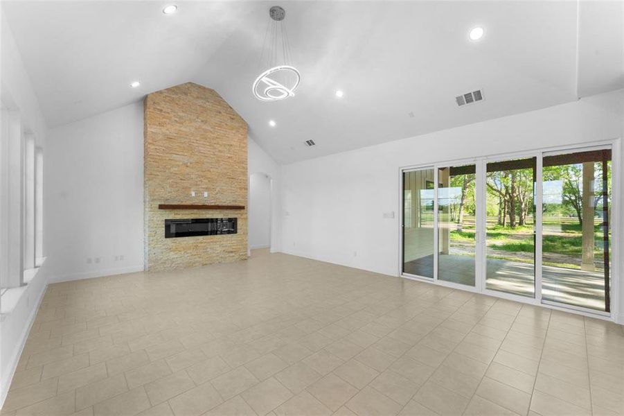 Unfurnished living room with high vaulted ceiling, a fireplace, recessed lighting, and arched walkways Unfurnished living room with high vaulted ceiling, a fireplace, recessed lighting, and arched walkways