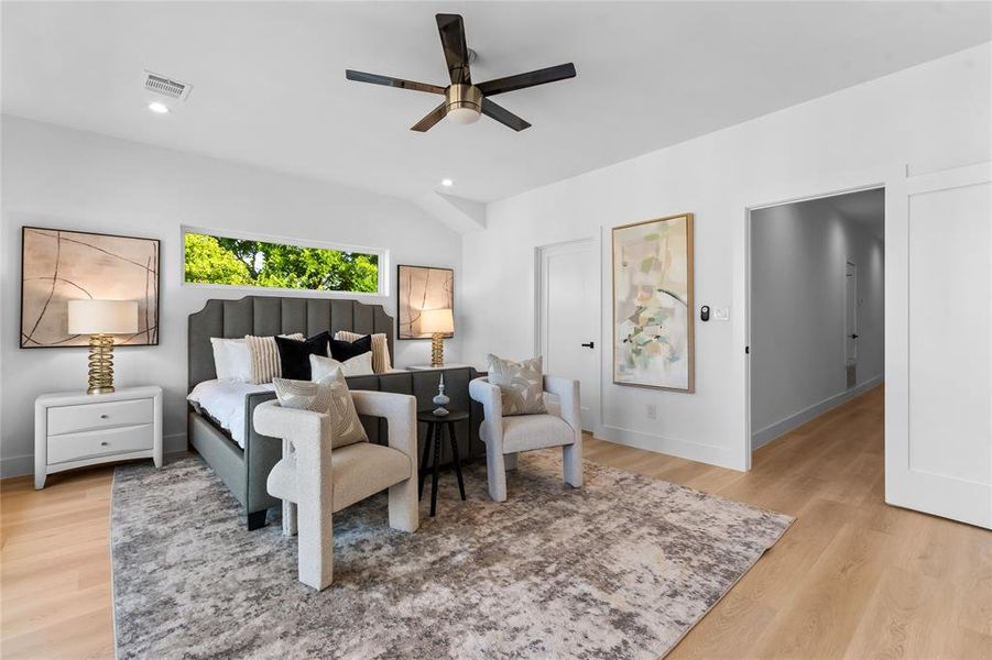Bright bedroom with vaulted ceilings, recessed lighting, a modern ceiling fan, and light wood-finish flooring Bright bedroom with vaulted ceilings, recessed lighting, a modern ceiling fan, and light wood-finish flooring