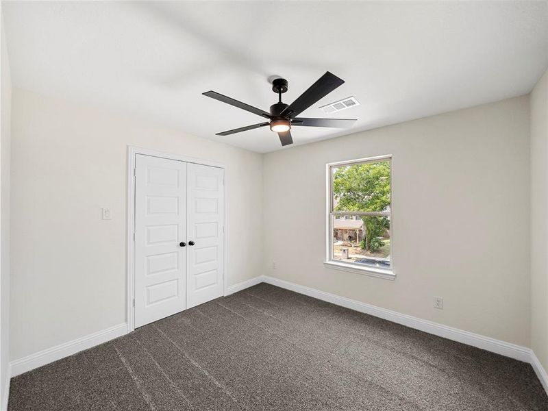 Unfurnished bedroom featuring ceiling fan, a closet, and carpet