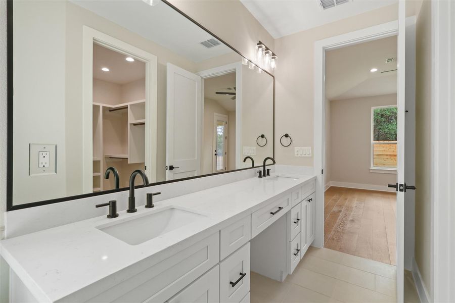 Full bathroom featuring double vanity, a sink, baseboards, and visible vents Full bathroom featuring double vanity, a sink, baseboards, and visible vents