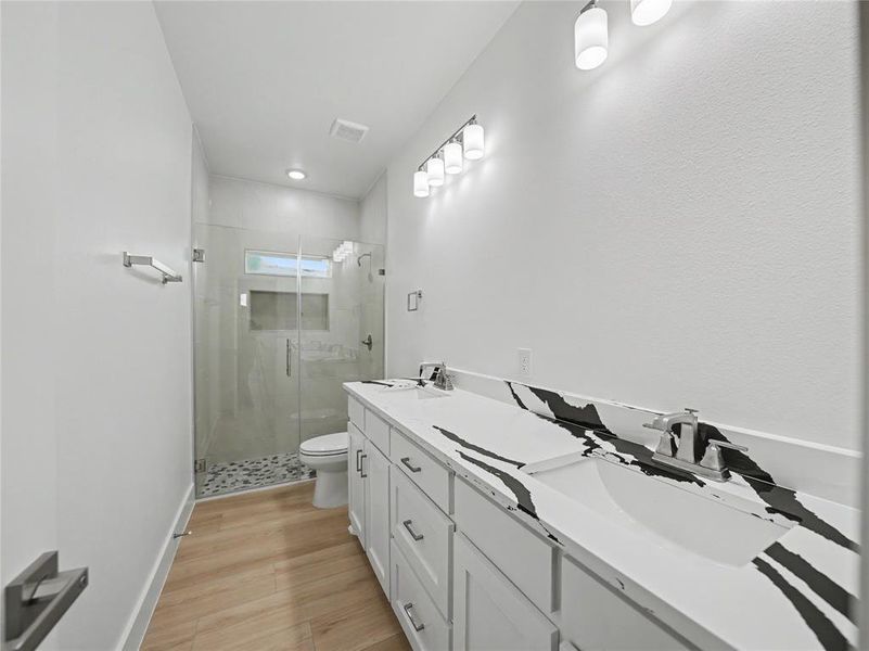 Dual vanity with white cabinetry and striking black and white patterned countertops Dual vanity with white cabinetry and striking black and white patterned countertops