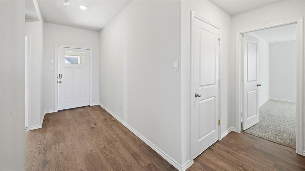 Corridor featuring dark wood-type flooring and baseboards