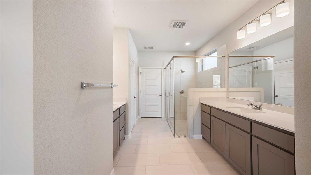 Bathroom featuring walk in shower, tile patterned floors, and vanity