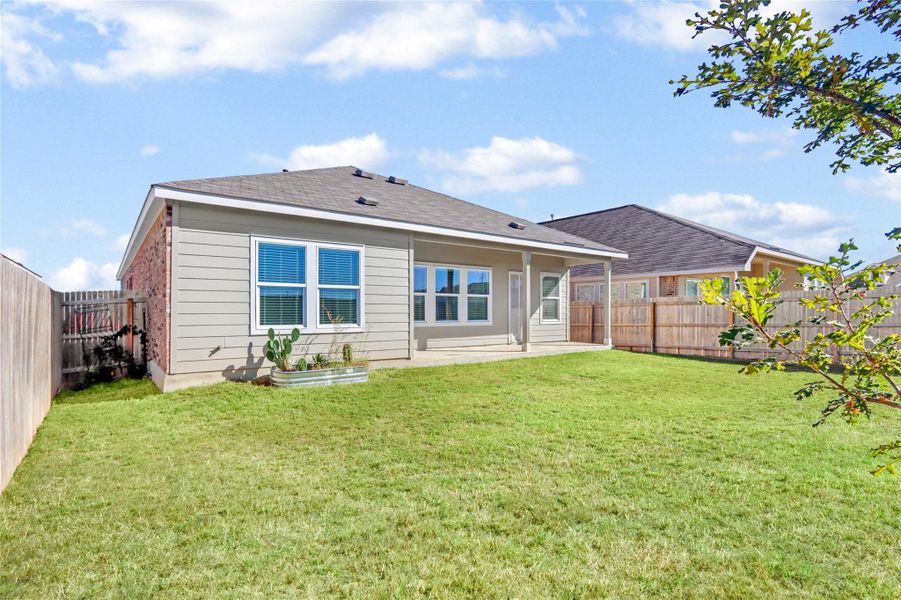 Rear view of property featuring a patio area, a fenced backyard, and a shingled roof