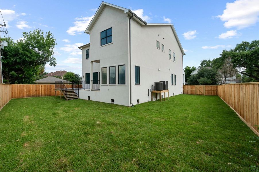 Expansive backyard with ample green space for a pool or future outdoor amenities. Expansive backyard with ample green space for a pool or future outdoor amenities.