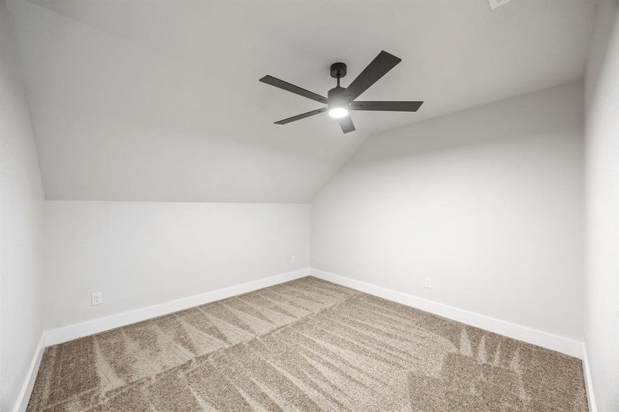 Bonus room with lofted ceiling, carpet floors, and a ceiling fan