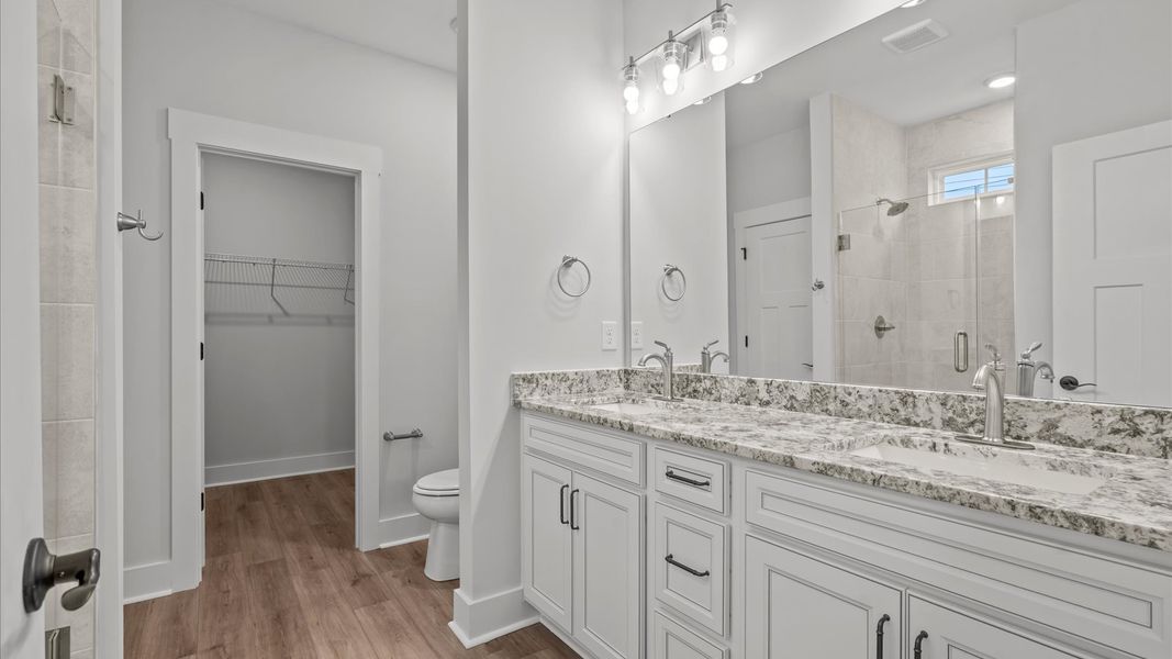 Notable primary suite with dual vanities and tiled walk-in shower in this prime Seneca home