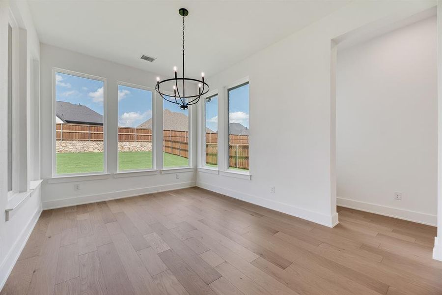 Unfurnished dining area featuring light wood-style floors and a chandelier