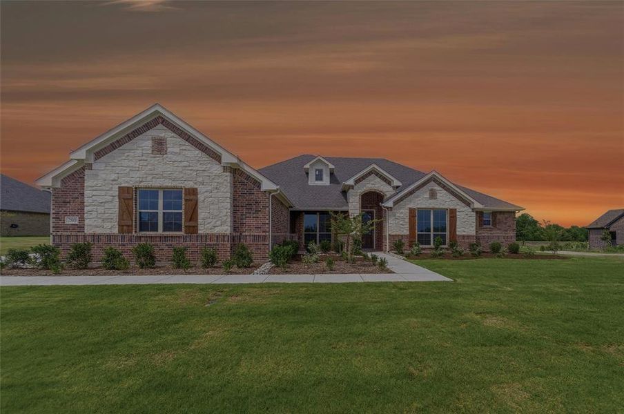 Brick and stone exterior featuring multiple gables, dark roof shingles, and a front-facing window with decorative wood shutters Brick and stone exterior featuring multiple gables, dark roof shingles, and a front-facing window with decorative wood shutters