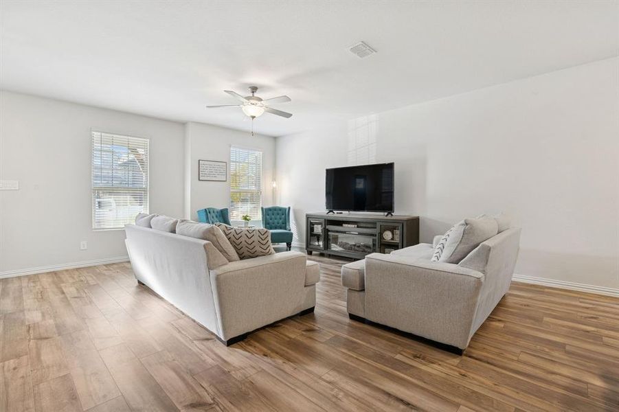 Living room with light wood-style flooring and ceiling fan
