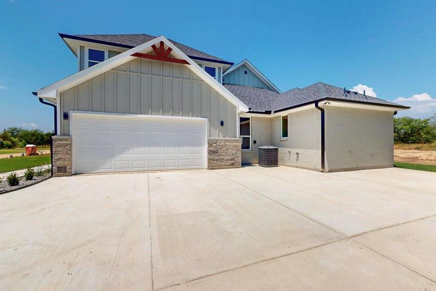 Craftsman house with board and batten siding, concrete driveway, an attached garage, and a shingled roof