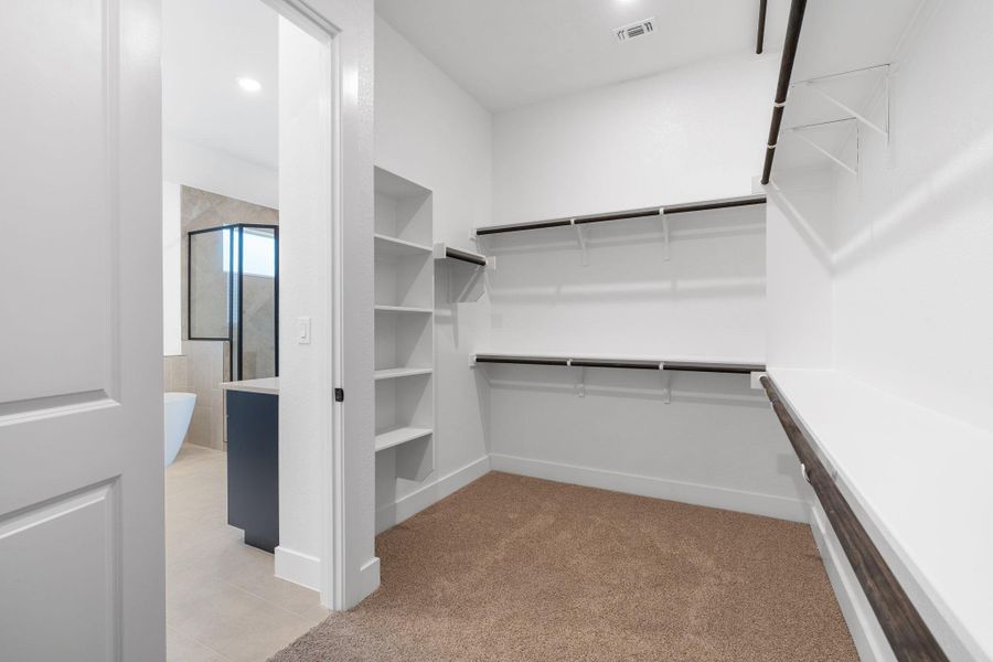 A spacious walk-in closet with ample shelving and hanging rods offers practical storage solutions.