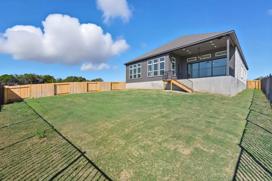 Rear view of property with a fenced backyard and a patio area