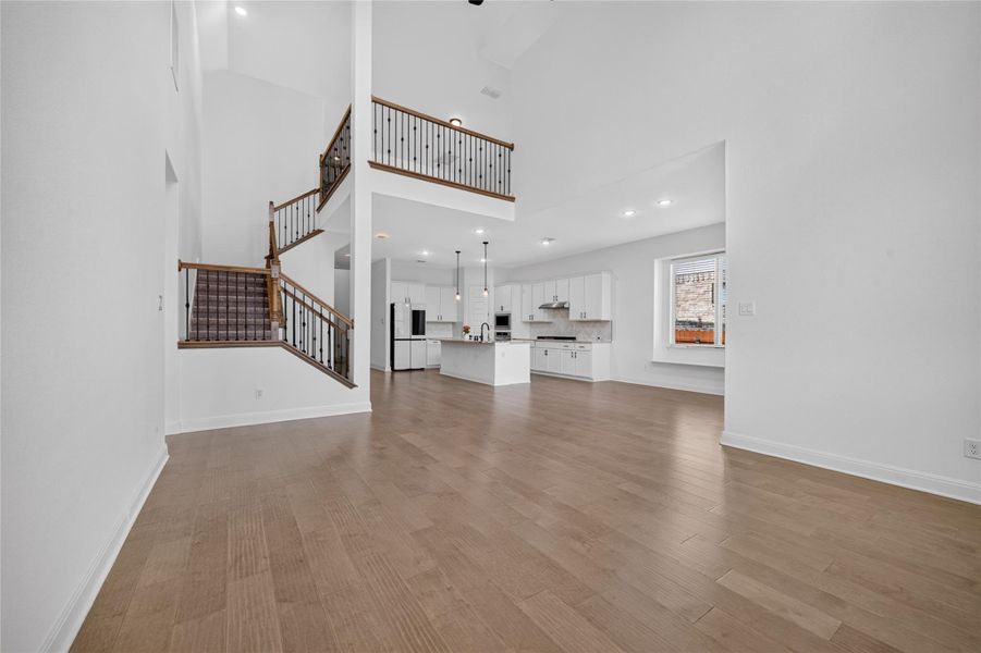 Gleaming hardwood floors run through a dramatic double-height main living area and open kitchen. Gleaming hardwood floors run through a dramatic double-height main living area and open kitchen.