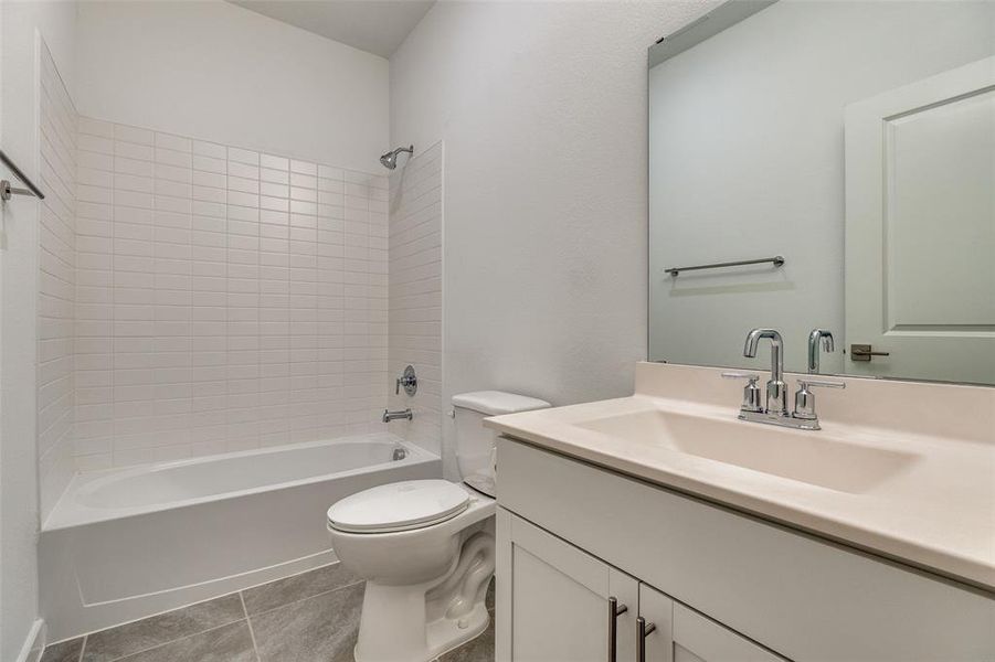 Full bath featuring shower / bathtub combination, vanity, and light tile patterned floors Full bath featuring shower / bathtub combination, vanity, and light tile patterned floors