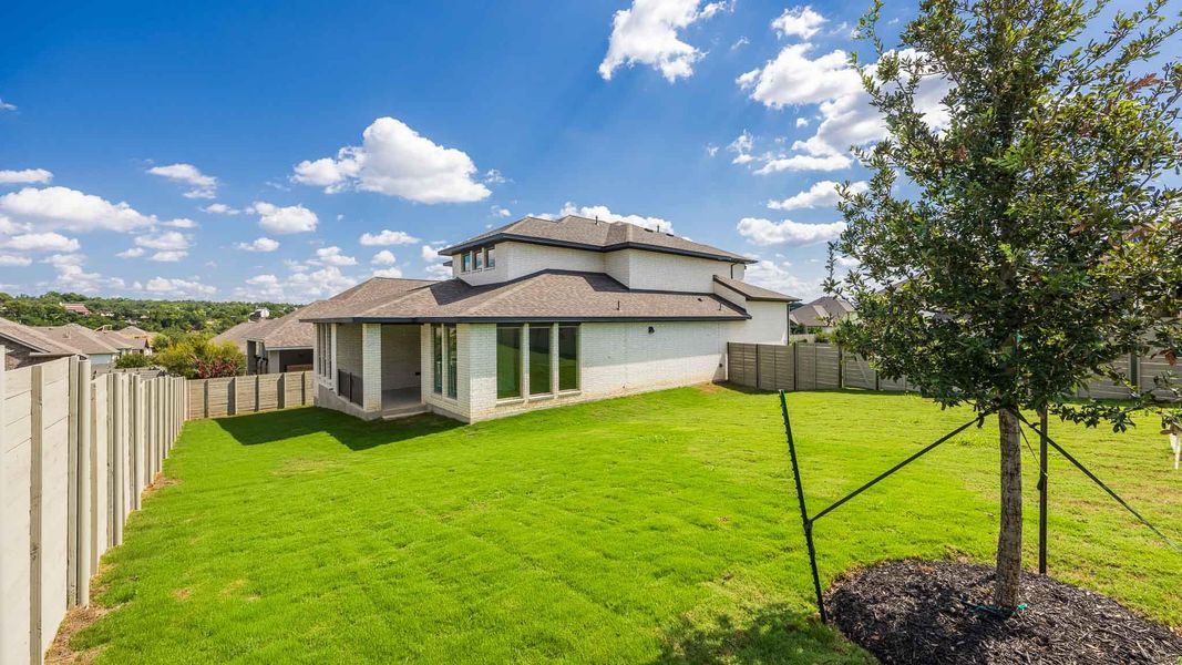 Back of property with brick siding, a shingled roof, and a fenced backyard Back of property with brick siding, a shingled roof, and a fenced backyard