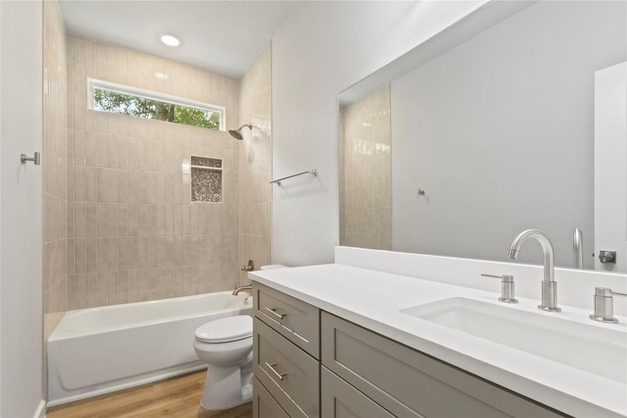 A gorgeous, spacious bathroom with a sleek vanity, a bath-shower combo, and brilliant natural light. A gorgeous, spacious bathroom with a sleek vanity, a bath-shower combo, and brilliant natural light.