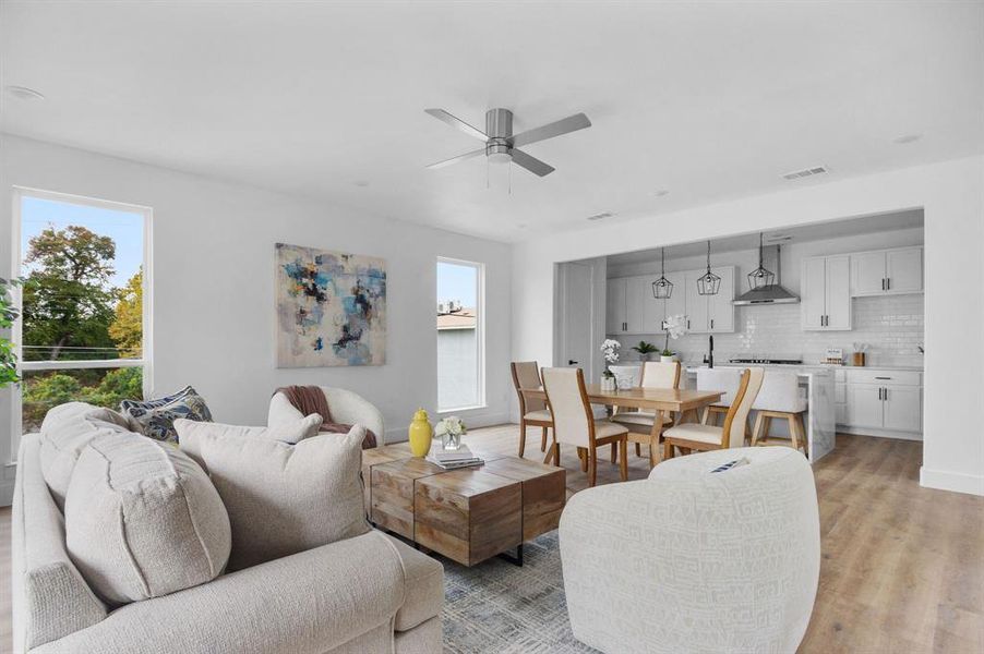 Living room featuring ceiling fan and light hardwood / wood-style flooring