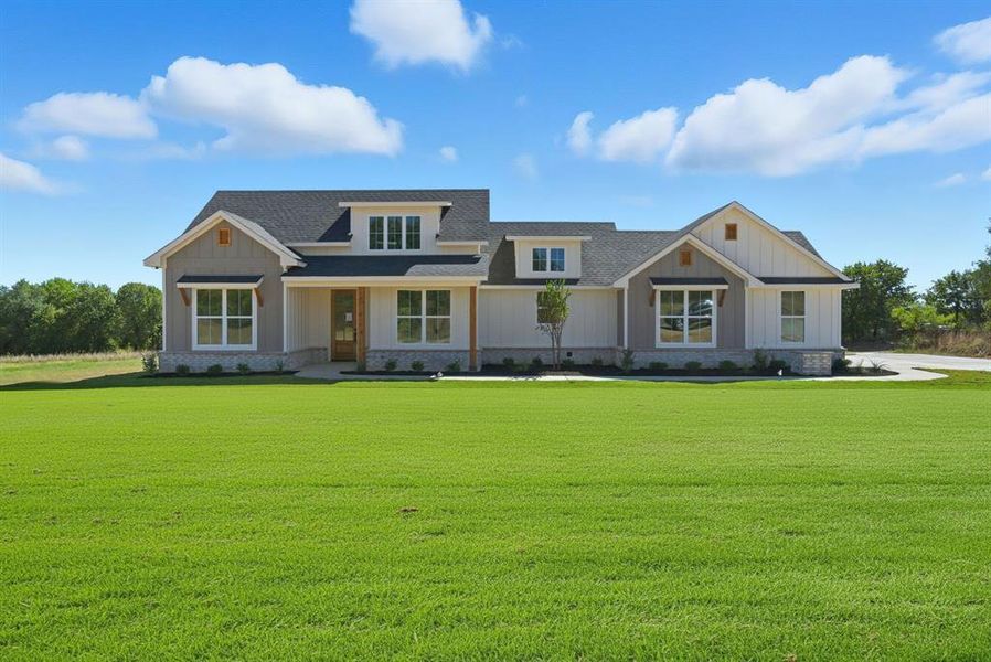 Craftsman house featuring a front lawn, board and batten siding, and stone siding