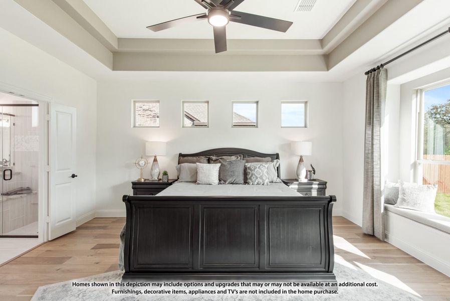 Master bedroom with tray ceiling, ceiling fan, dark wood sleigh bed, hardwood floors, and window seat