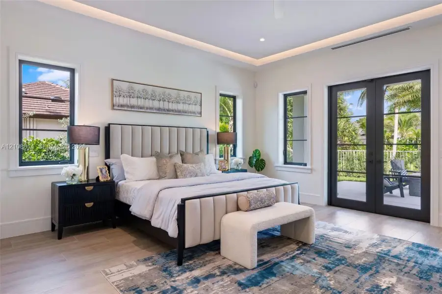 Tray ceiling with integrated recessed lighting, light-toned porcelain-finish flooring, and black-framed windows and dual-lite French doors Tray ceiling with integrated recessed lighting, light-toned porcelain-finish flooring, and black-framed windows and dual-lite French doors