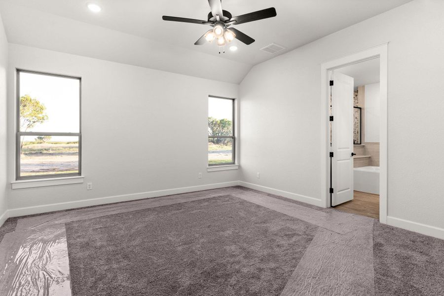 Empty room with light colored carpet, vaulted ceiling, ceiling fan, and recessed lighting Empty room with light colored carpet, vaulted ceiling, ceiling fan, and recessed lighting