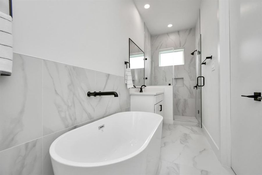 Refresh and revitalize in the modern comfort of the primary bath’s spacious glass frame walk-in shower