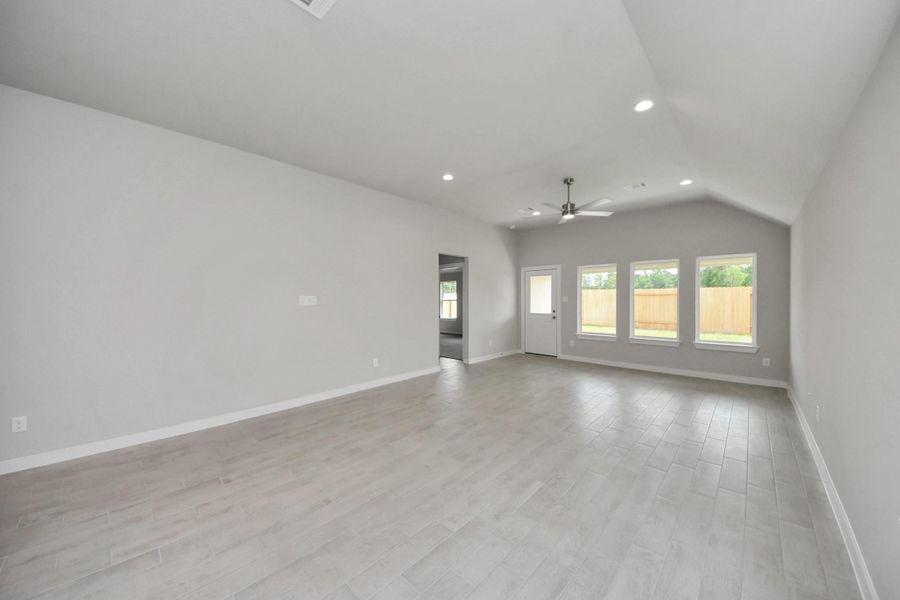 Welcome family and guests to your charming living room! With its high ceilings, recessed lighting, ceiling fan, custom paint, beautiful flooring, and large windows that let in abundant natural light, this room is perfect for gatherings. Sample photo of completed home with similar floor plan. Actual colors and selections may vary.