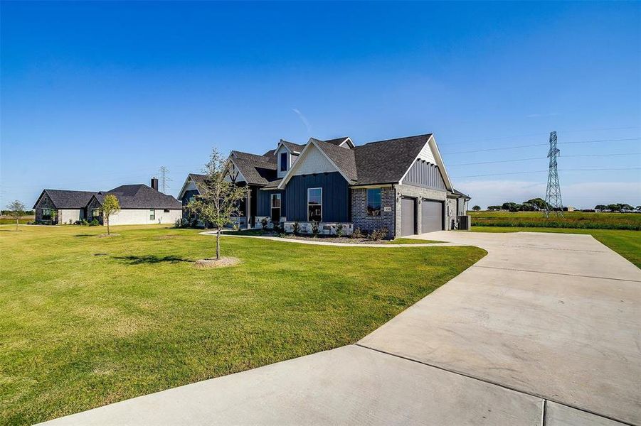 View of front of property featuring a front yard and a garage