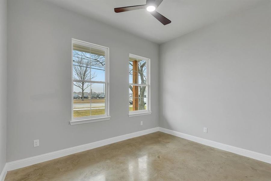 Empty room with finished concrete flooring and ceiling fan