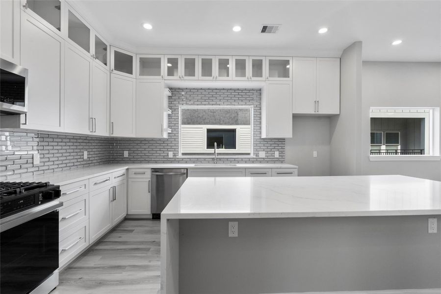 Kitchen is equipped with a gas range, Quartz counters and a shaker style cabinets Kitchen is equipped with a gas range, Quartz counters and a shaker style cabinets