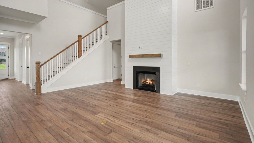 Gathering room with fireplace, high ceiling, and windows
