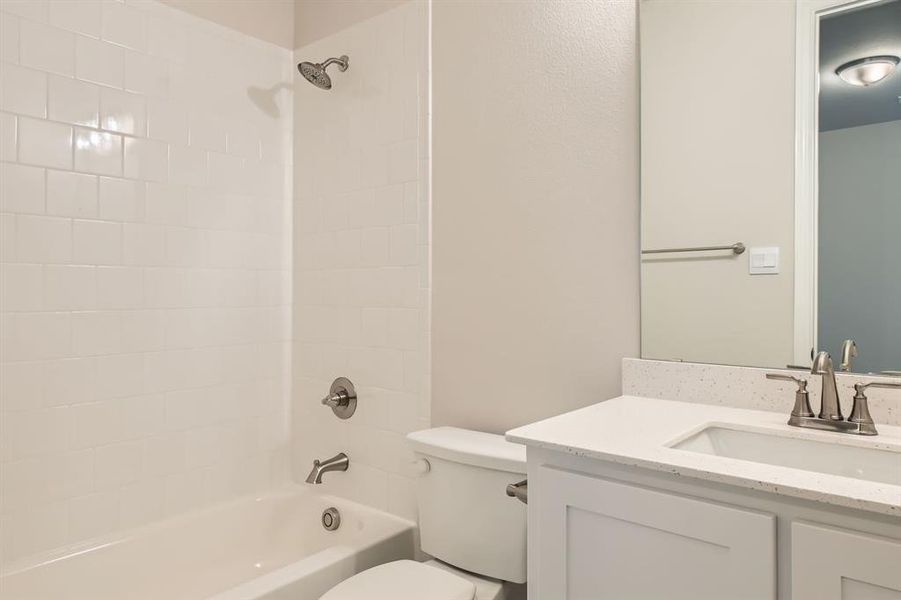 Full bathroom with vanity, tiled shower / bath, and toilet