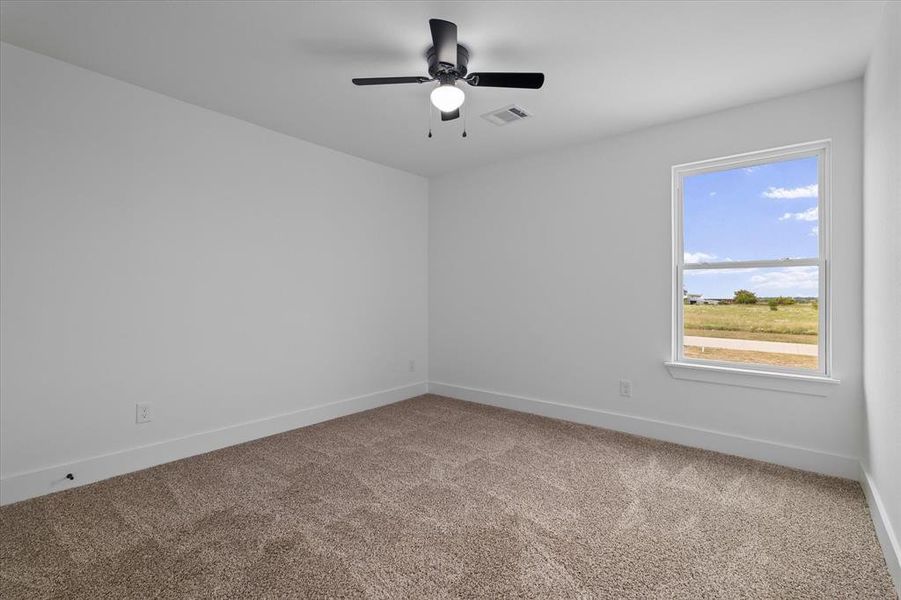 Empty room with light colored carpet and ceiling fan Empty room with light colored carpet and ceiling fan