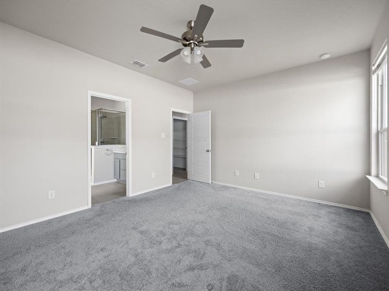 Unfurnished bedroom featuring carpet flooring, a ceiling fan, and connected bathroom Unfurnished bedroom featuring carpet flooring, a ceiling fan, and connected bathroom