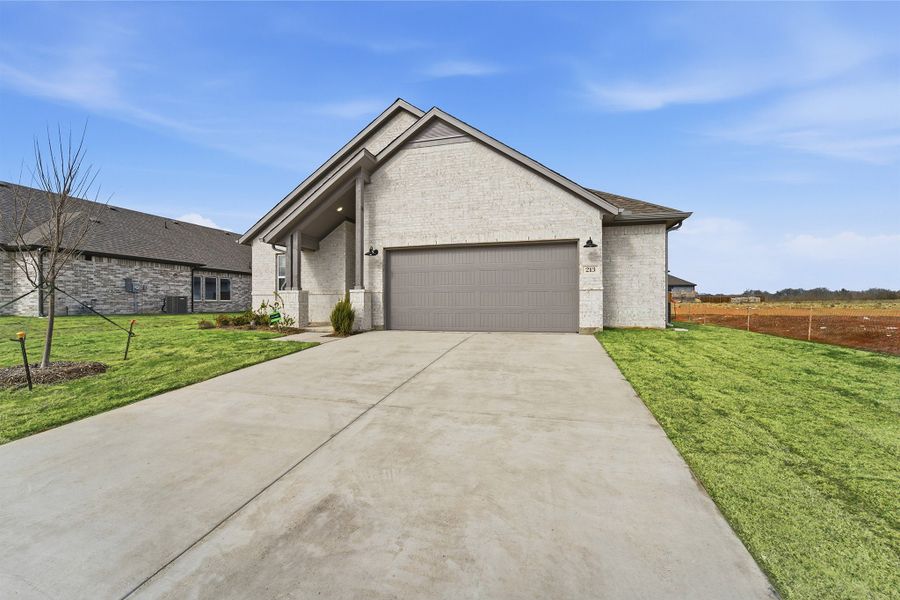 Front exterior of a new home in Saddlebrook Estates, Waxahachie, TX, highlighting curb appeal (Image 26). Front exterior of a new home in Saddlebrook Estates, Waxahachie, TX, highlighting curb appeal (Image 26).