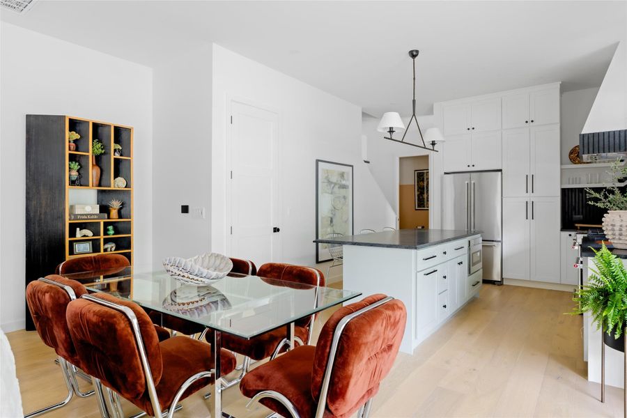 Dining space with light wood-style floors and a chandelier